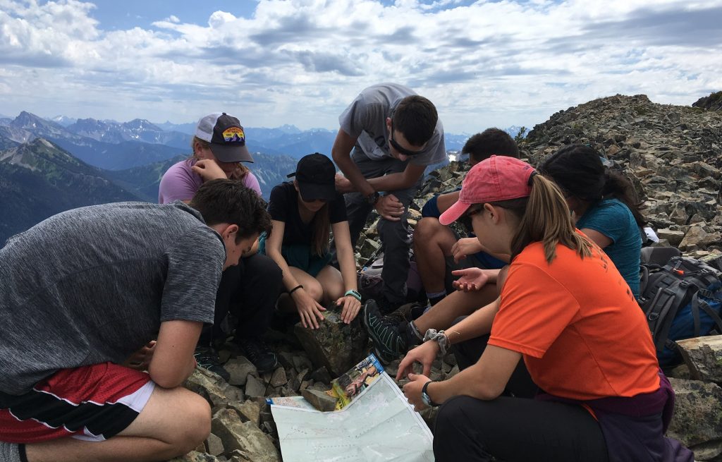 teenagers navigating map british columbia mountains
